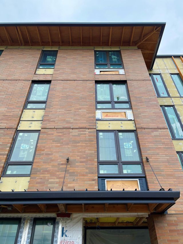A brick building with a lot of windows under construction.