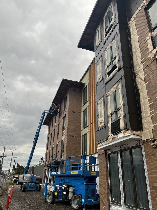 A building under construction with a crane on the side of it.