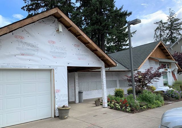 A car is parked in front of a house that is being remodeled.