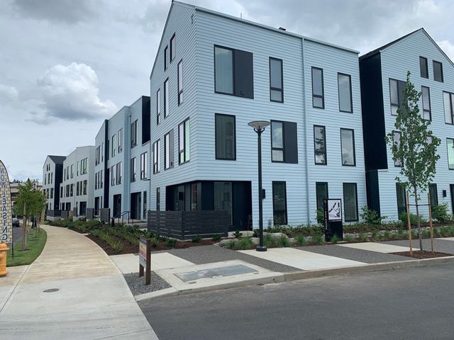 A row of buildings with a sidewalk in front of them.