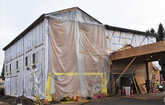 A large building is covered in plastic while being built.
