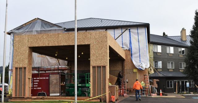 A building is being built with a roof that is covered in plastic.