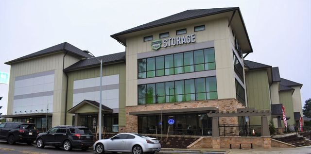 A large building with a lot of windows and cars parked in front of it.