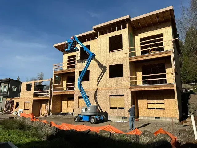 A large building is being built with a crane in front of it.