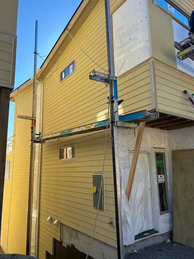 A yellow house with scaffolding on the side of it