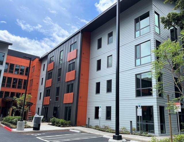 A large apartment building with a parking lot in front of it