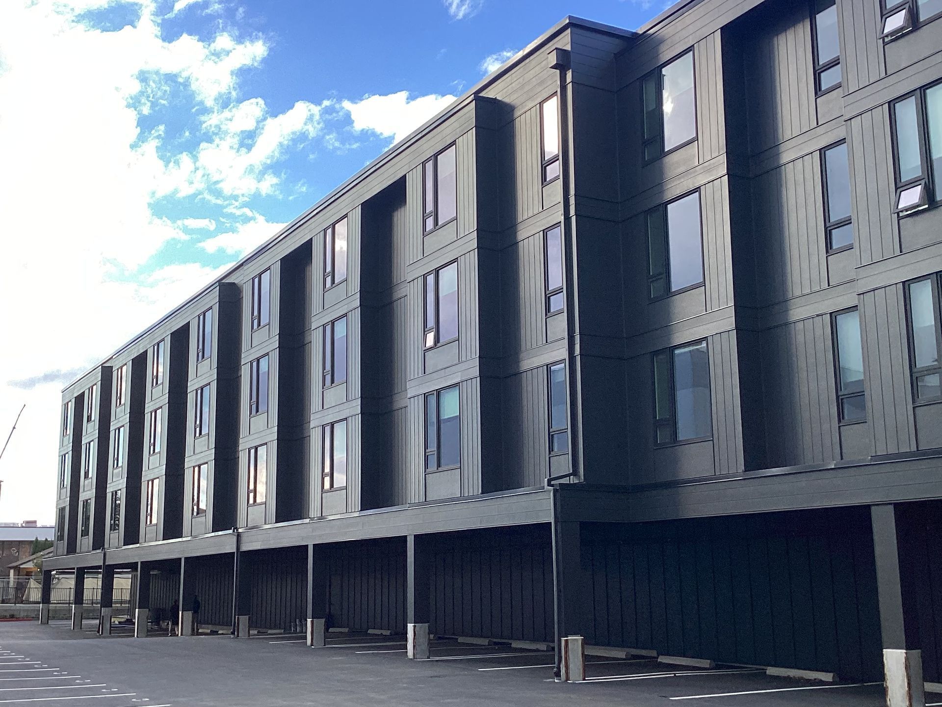 A large building with a lot of windows and a parking lot in front of it