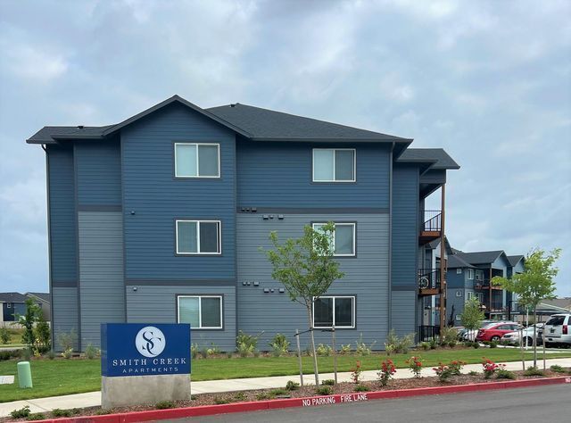 A large apartment building with a blue sign in front of it