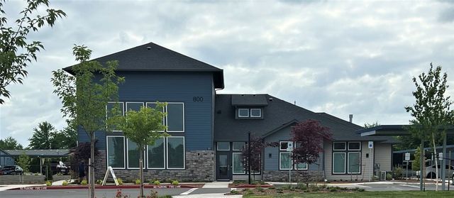 A large building with a lot of windows and trees in front of it