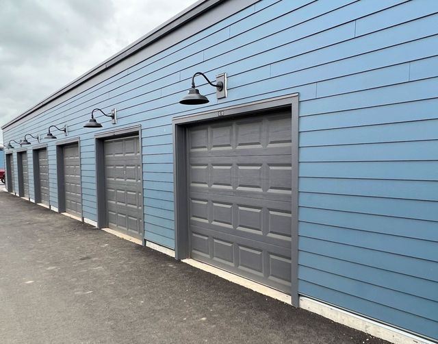 A row of garage doors on a blue building