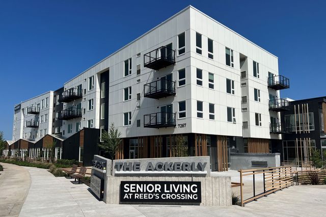 A building with a sign that says senior living at reed 's crossing