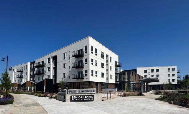 A large white apartment building with a sign that says ' spacious living ' on it.