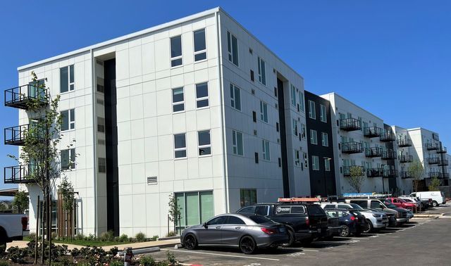 A large white building with cars parked in front of it