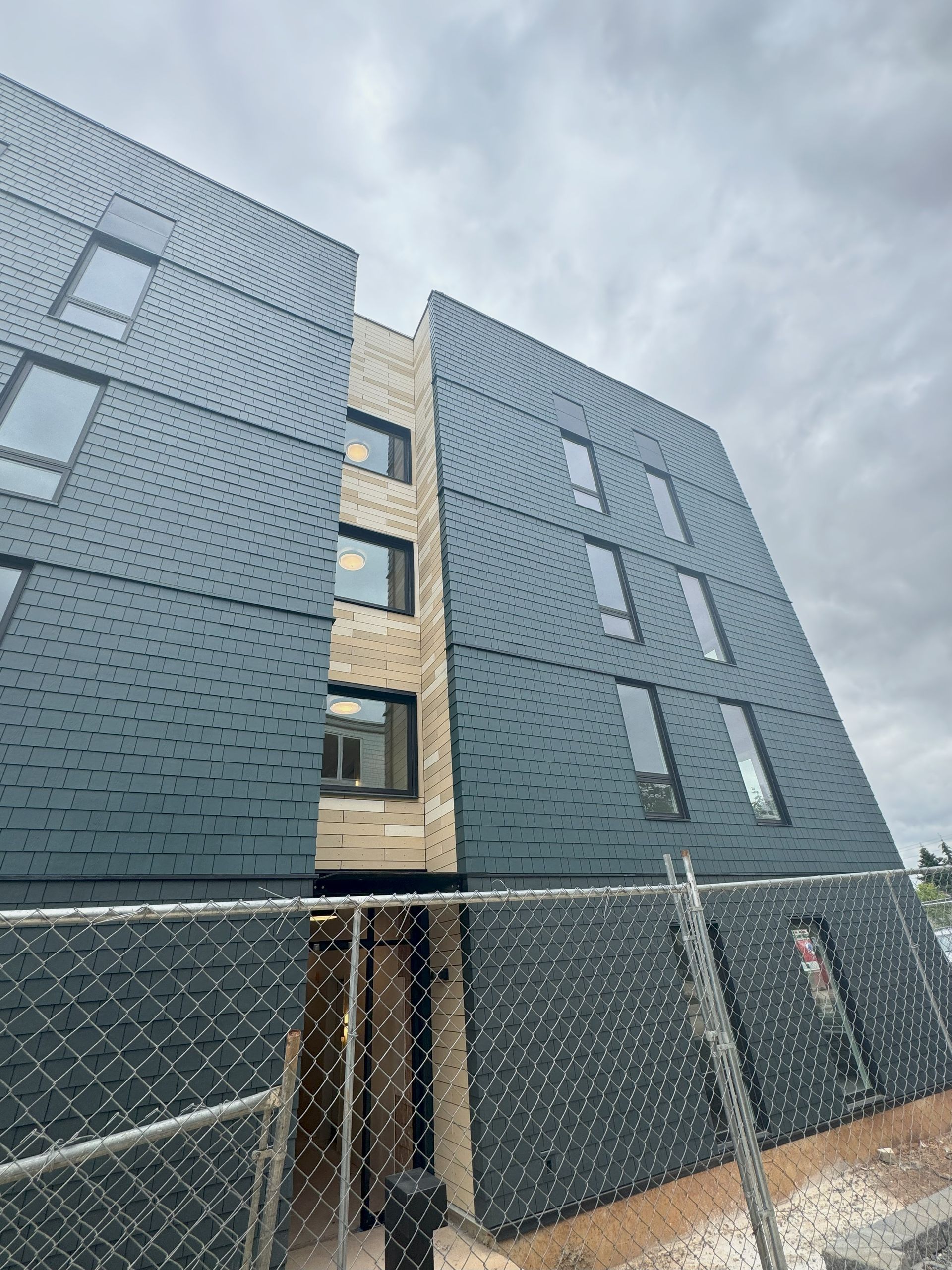 A building under construction with a chain link fence around it.