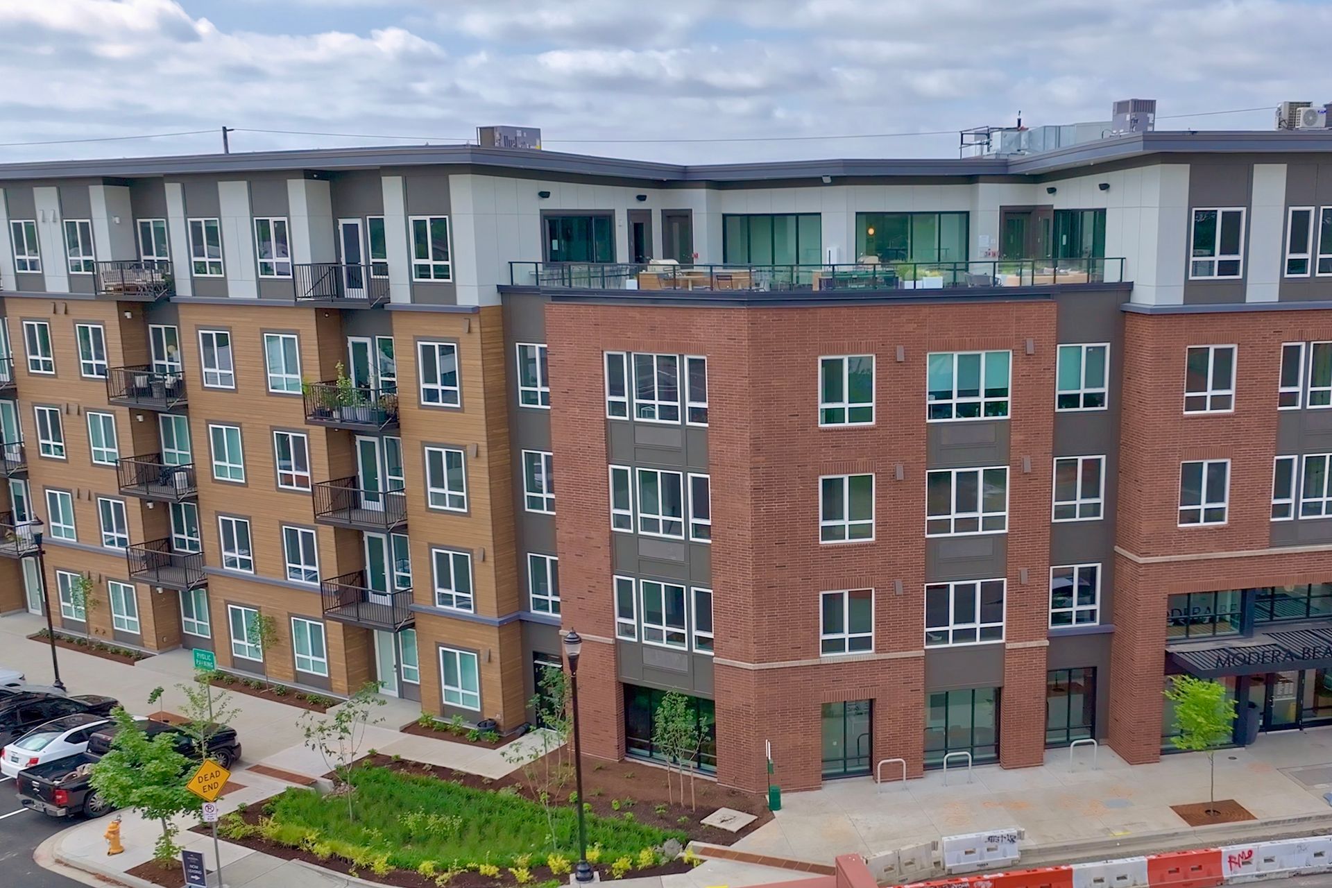A large apartment building with a lot of cars parked in front of it