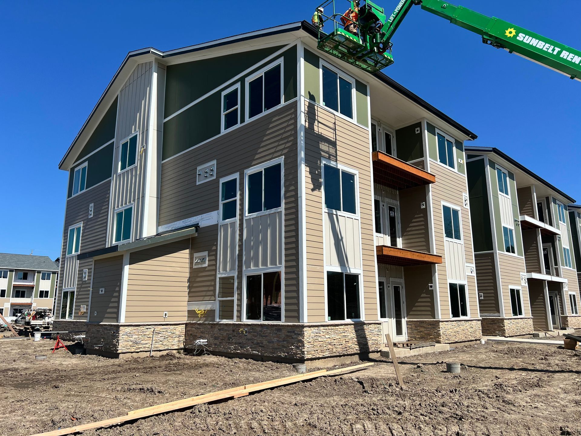 A large apartment building under construction with a crane on top of it.