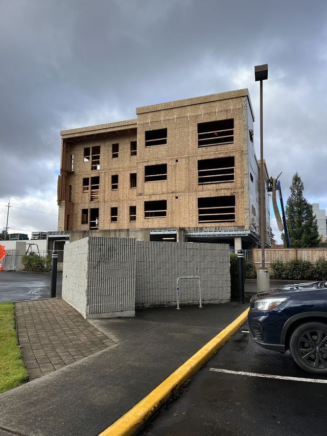 A car is parked in front of a building under construction