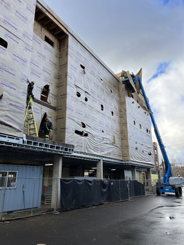 A large building is being built with a crane on top of it.