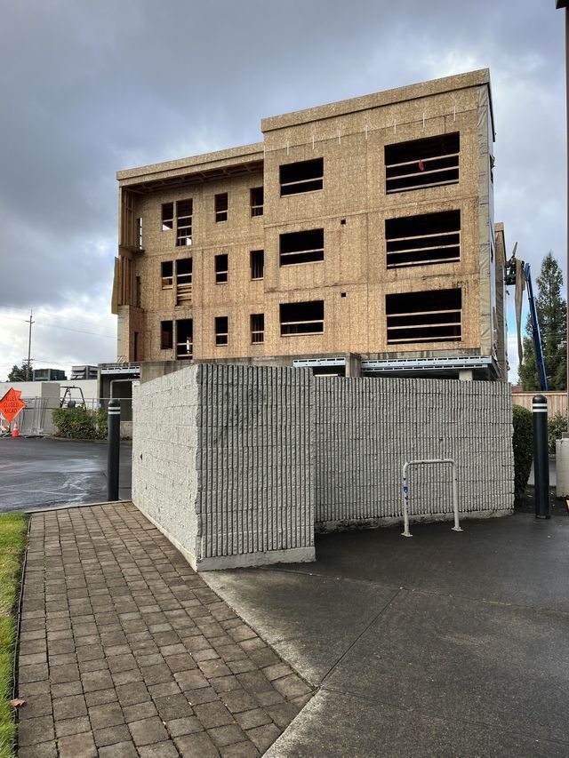 A building under construction with a brick walkway in front of it