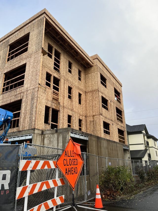 A building under construction with a closed ahead sign in front of it.