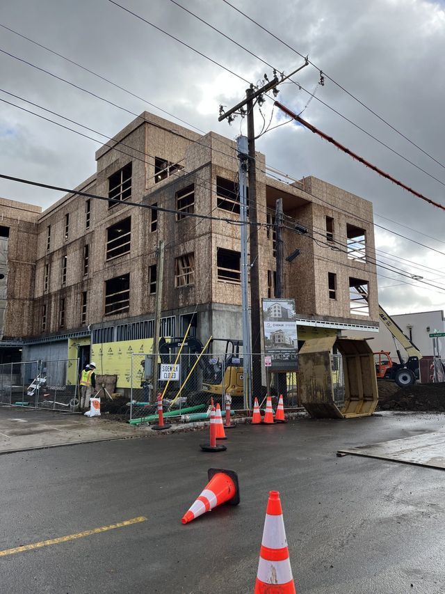 A building under construction with a lot of cones in front of it