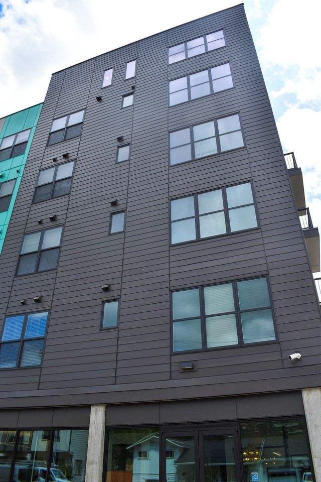 A tall building with a lot of windows and a blue sky in the background.