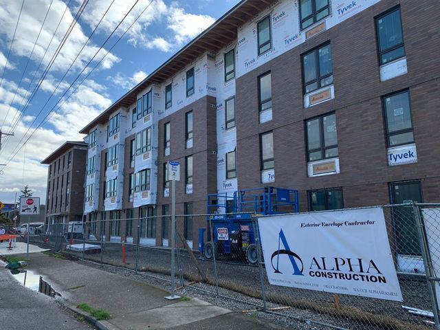 A building under construction with a sign that says alpha construction