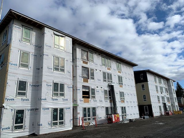 A large apartment building under construction with a lot of windows.