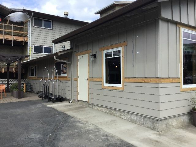 A gray building with a white door and a lot of windows