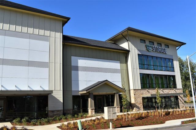 A large building with a lot of windows is sitting on the side of the road.