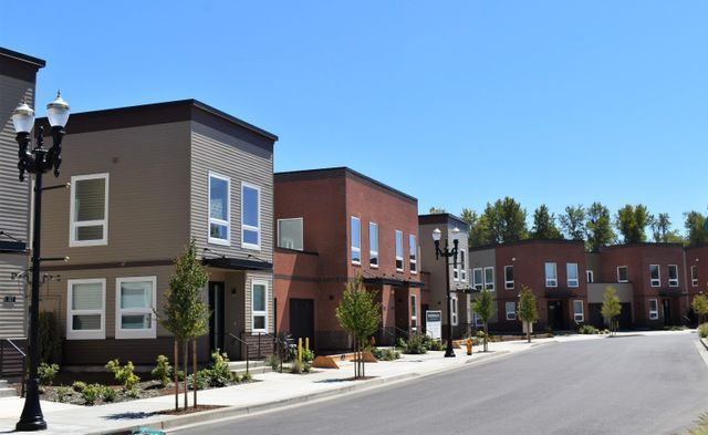 A row of houses are lined up on the side of a street