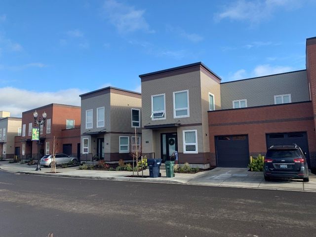 A row of houses with cars parked in front of them