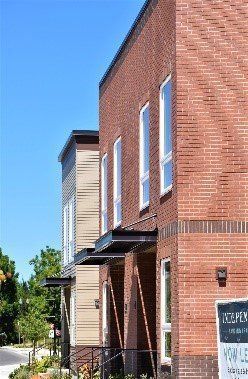 A brick building with a sign on the side that says `` for sale ''.