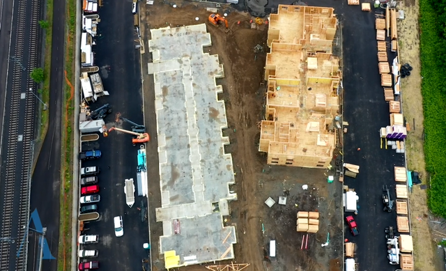 An aerial view of a building under construction next to a highway.