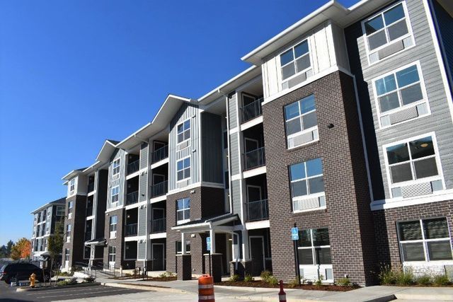 A large apartment building with a lot of windows on a sunny day.