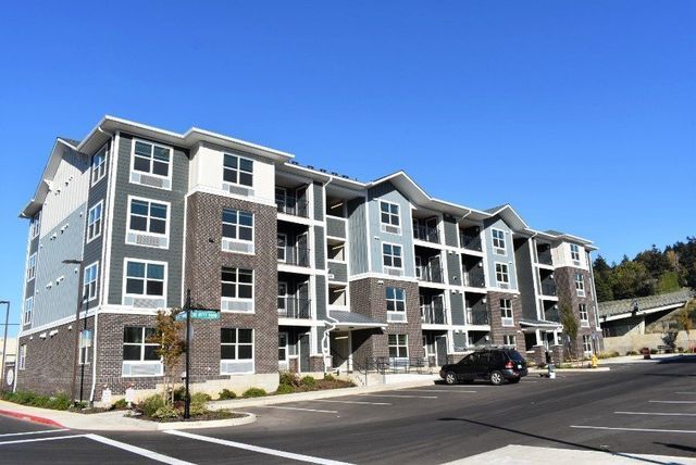 A large apartment building with a car parked in front of it.
