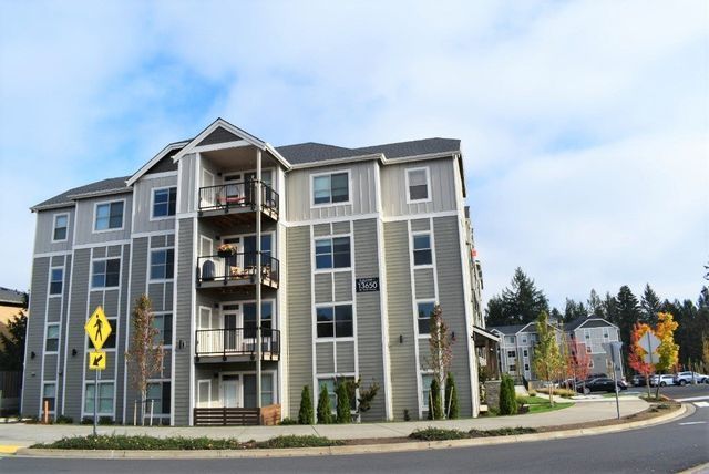 A large apartment building with a crosswalk sign in front of it