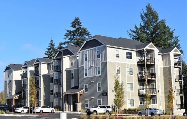 A large apartment building with cars parked in front of it