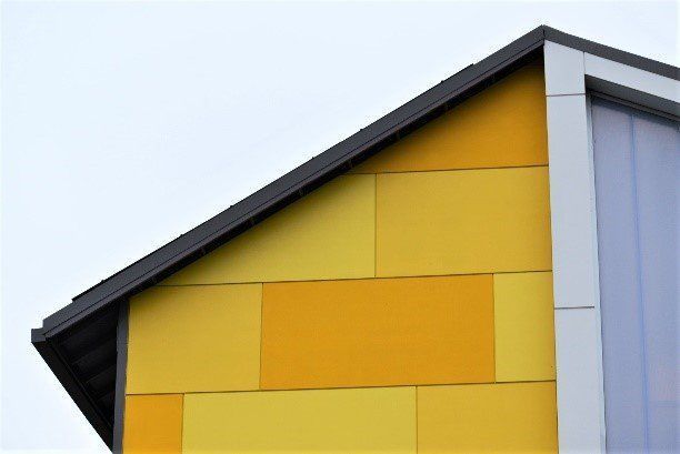 A yellow building with a black roof