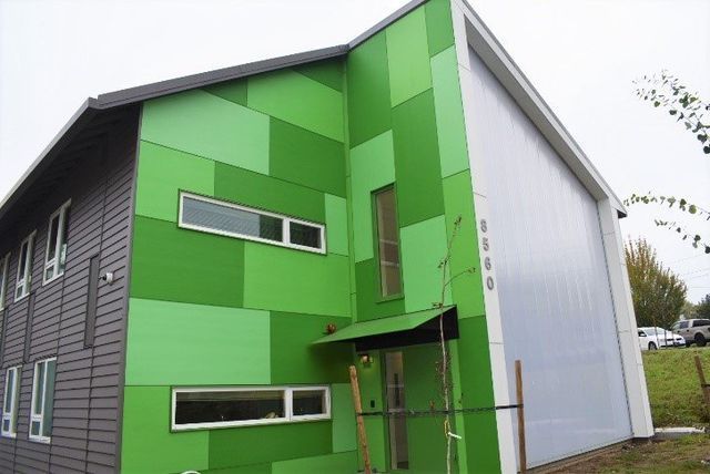 A large green building with a white garage door
