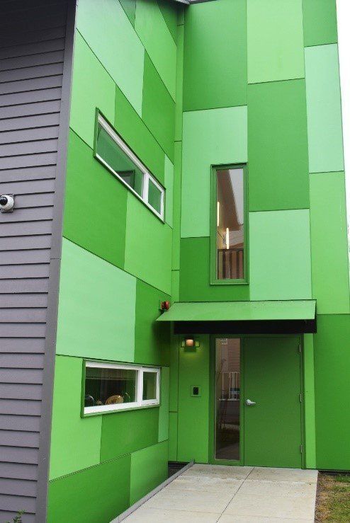 A green building with a door and windows