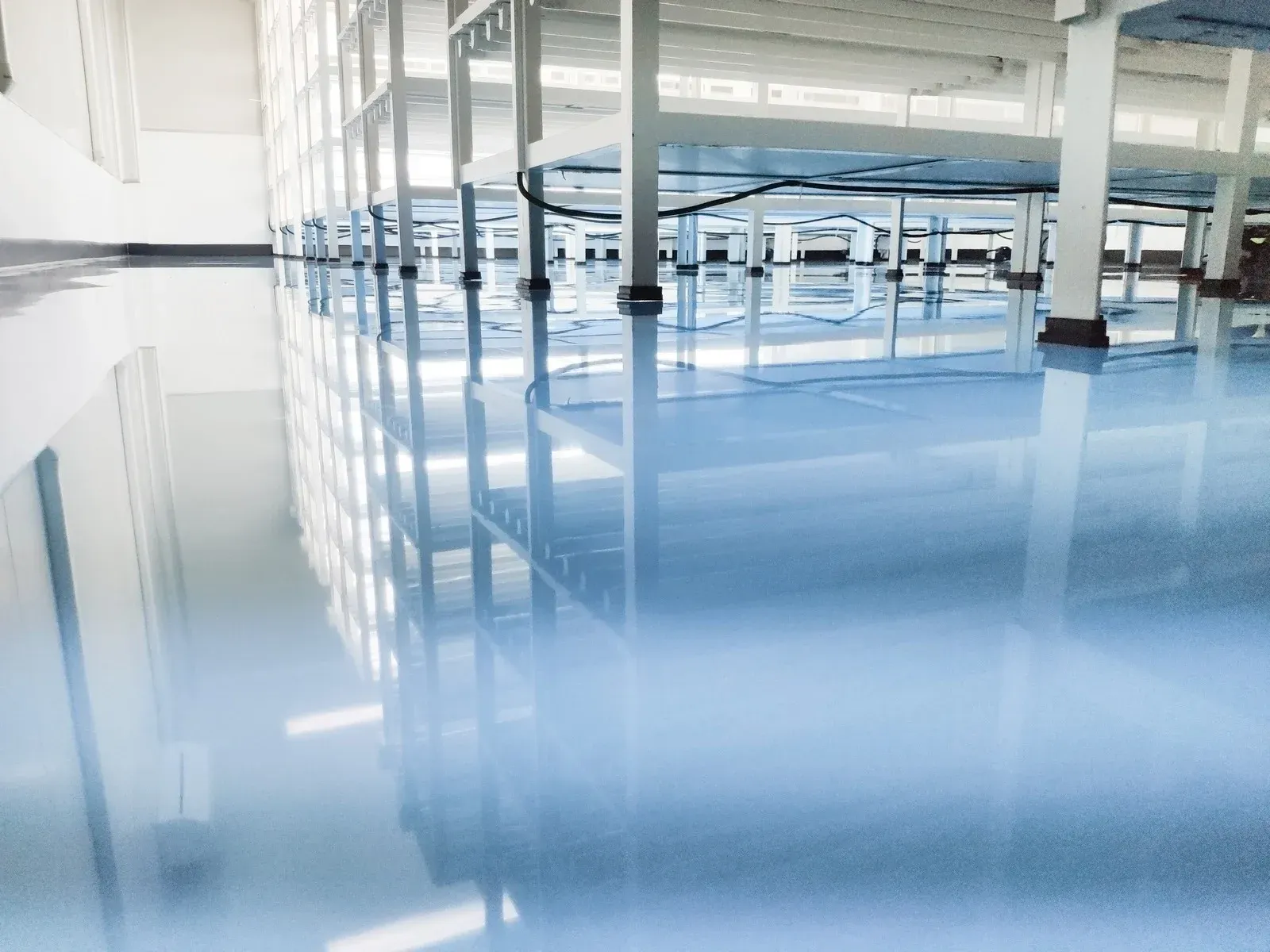 A large room with a lot of windows and a blue floor.