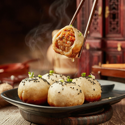 Chopsticks hold a steaming, golden-brown pan-fried bun with a meaty filling over a platter of similar buns.