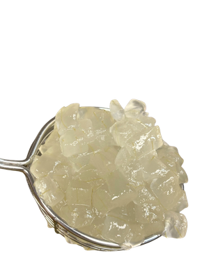 Cubes of translucent, gelatinous substance in a metal mesh strainer, held against a white background.