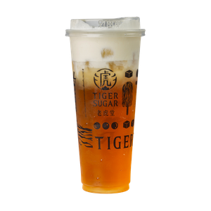 Tiger Sugar drink: layered orange tea, creamy foam, in a branded clear plastic cup.