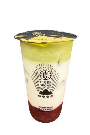 Tiger Sugar bubble tea with a flan topping, caramel swirls, and milk splash.