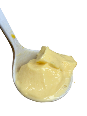 Close-up of a white spoon holding a portion of yellow pudding.