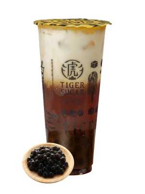 Tiger Sugar bubble tea with brown sugar stripes, layered with milk and boba, cup with lid, small bowl of boba.
