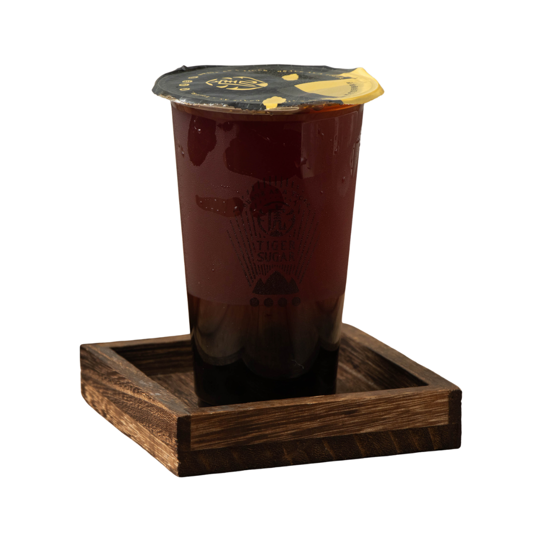 Iced tea in a clear cup, sealed with a lid, on a small wooden tray.