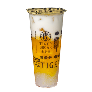Tiger Sugar mango boba tea in a clear plastic cup with layers of mango, milk, and tapioca pearls.